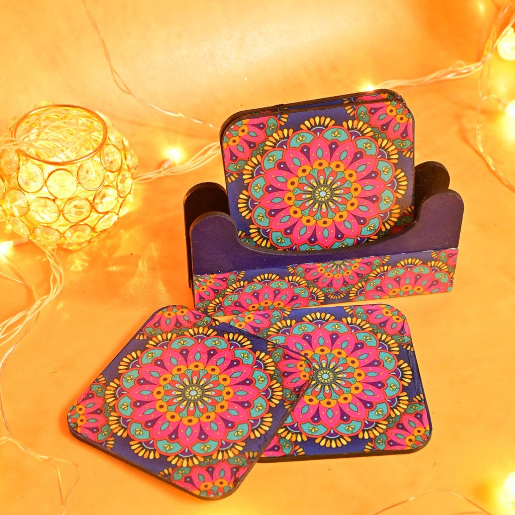 Colorful coasters with intricate mandala designs in a holder, surrounded by warm string lights and a glowing orb, create a cozy, festive mood.