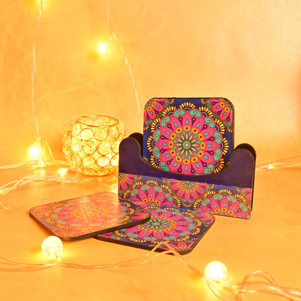 Colorful coasters with intricate mandala designs in a holder, surrounded by warm string lights and a glowing orb, create a cozy, festive mood.