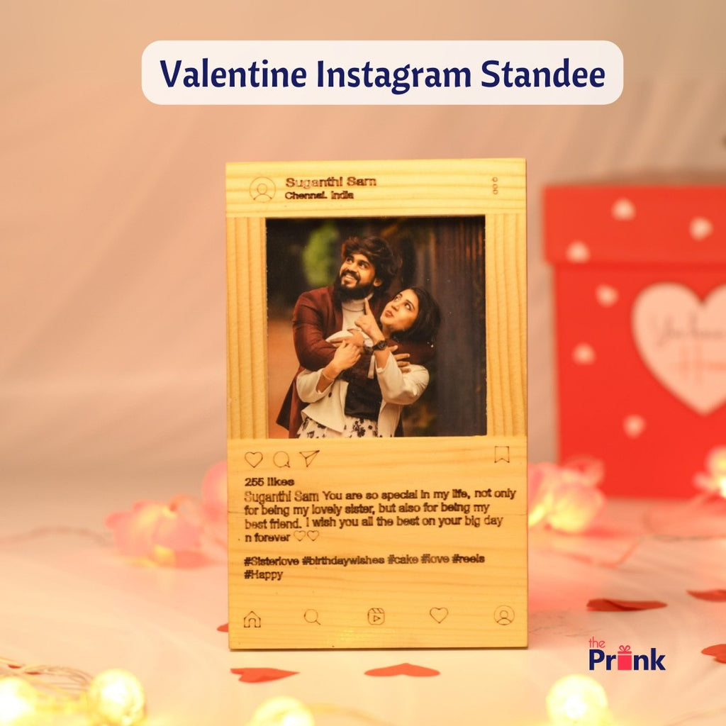 A wooden Instagram-themed standee displays a couple embracing, with a message celebrating friendship and love. Warm fairy lights and a heart-themed box add a romantic touch.