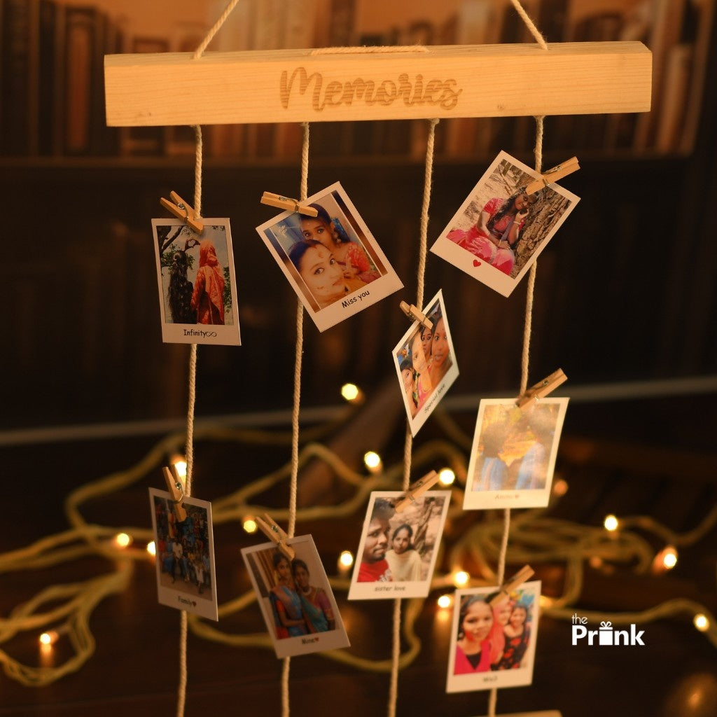 Hanging wooden frame labeled "Memories" holds photos clipped on strings. Background features warm fairy lights creating a nostalgic, cozy ambiance.