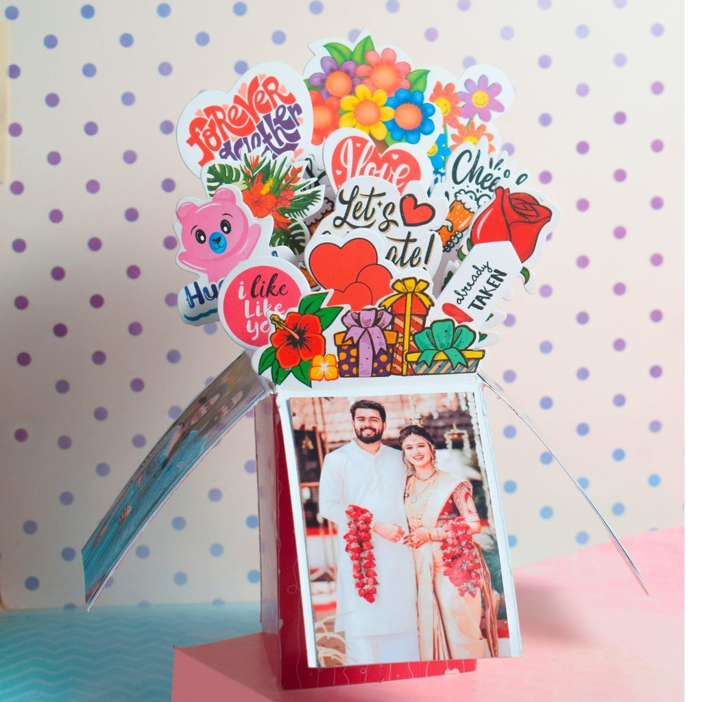 Red pop-up card featuring colorful cutouts of hearts, flowers, and phrases like "Forever Together" and "I Love You." Three photos of smiling couples.