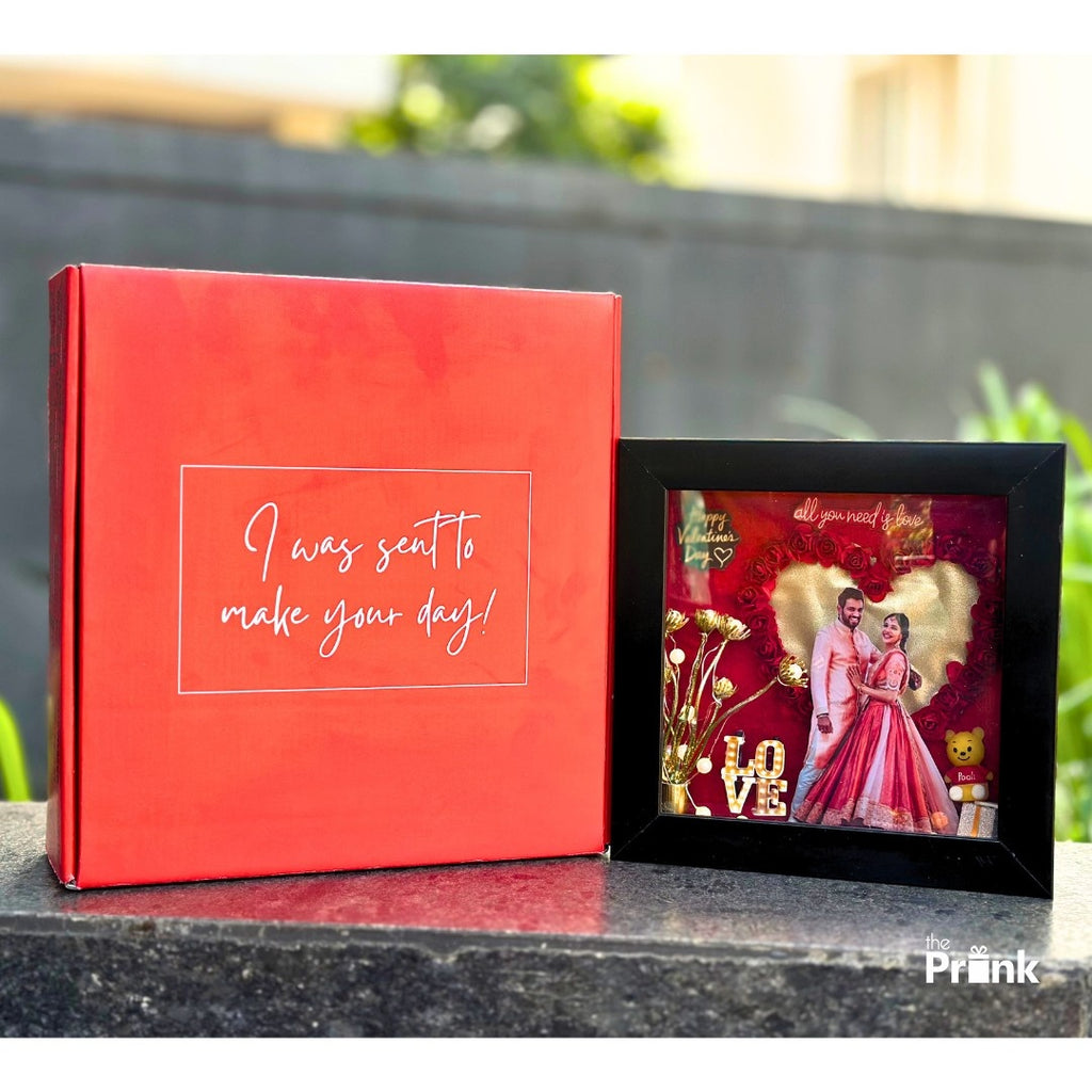 A red gift box with text "I was sent to make your day!" next to a romantic shadow box with a couple, heart, roses, and the word "LOVE"