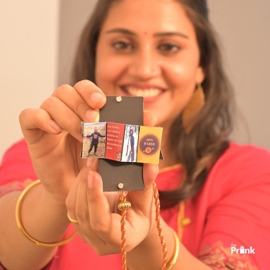 Smiling woman in a pink outfit holds a Rakhi with photos and a "Happy Rakhi" message, conveying warmth and celebration.