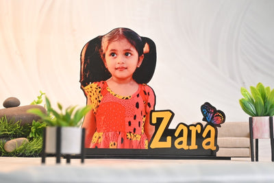 A cutout standee of a young girl in an orange dress with the name 