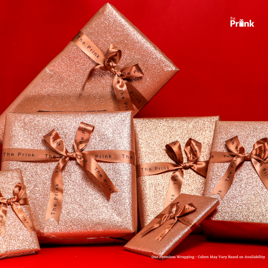 A stack of glittering, rose gold gift boxes tied with satin bows on a vibrant red background, conveying an elegant and festive atmosphere.